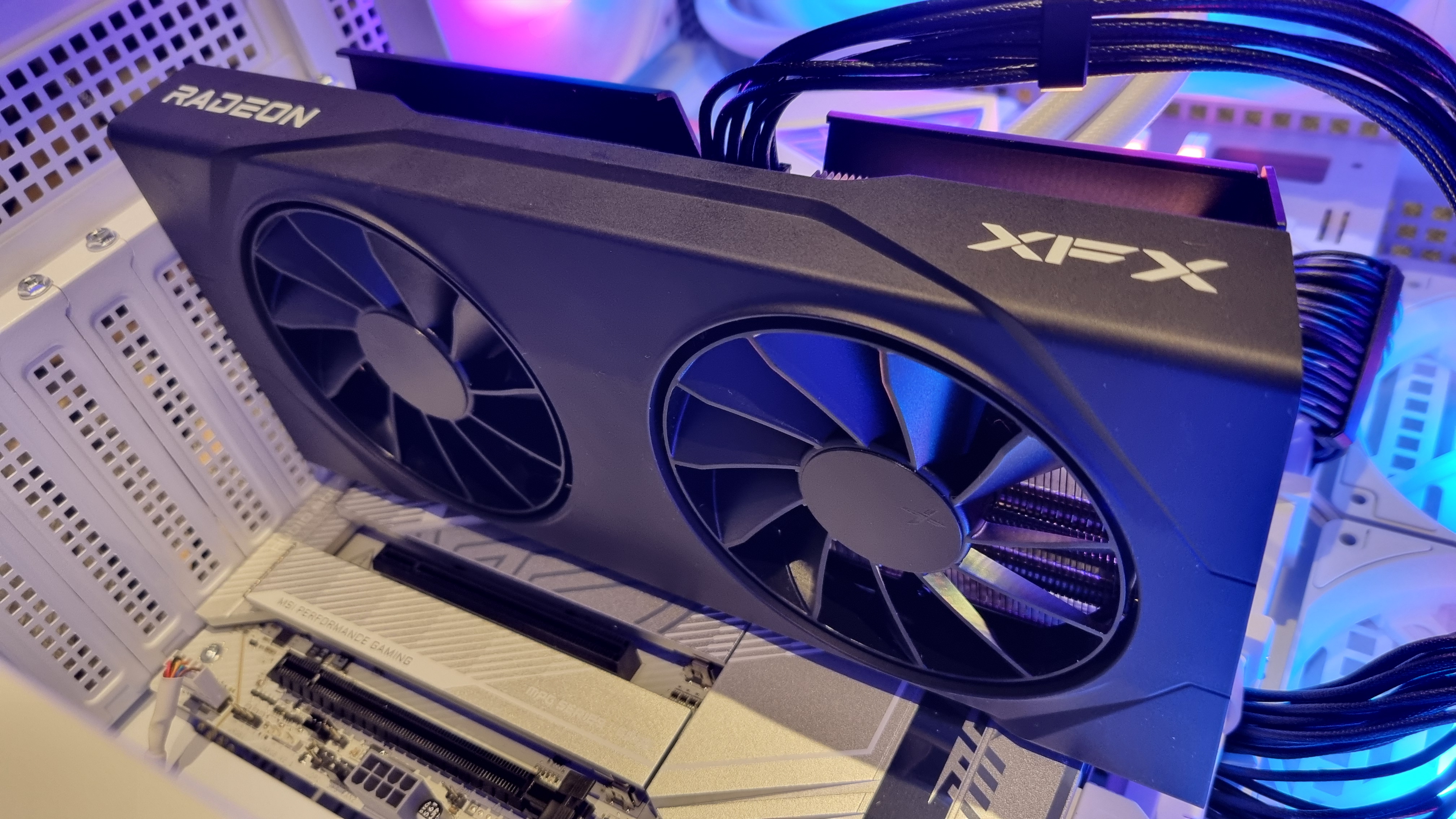 The XFX Swift AMD Radeon RX 9060 XT in a benchmarking PC, lit up with RGB