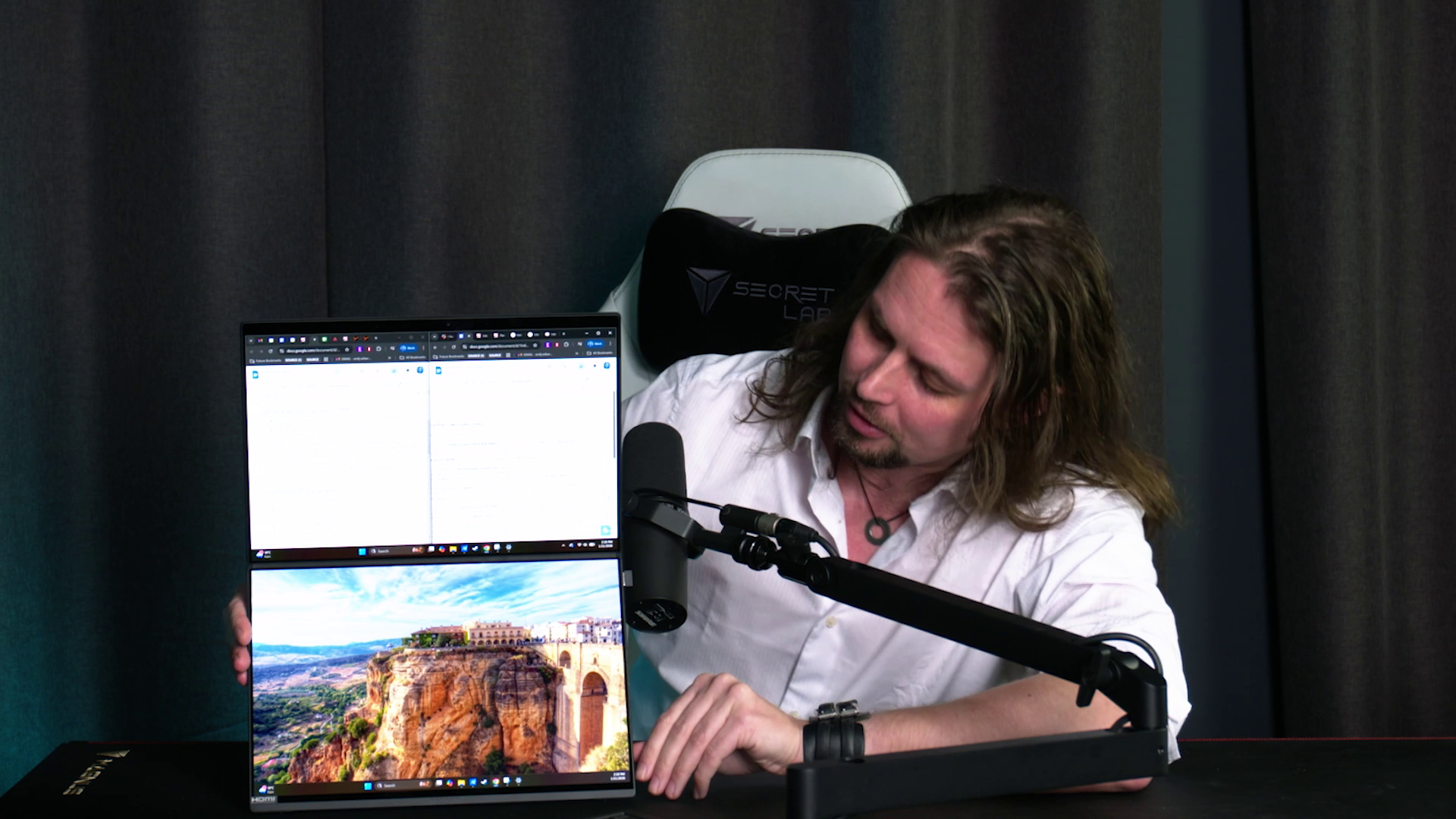 PC Gamer hardware writer Andy Edser demonstrating the dual OLED displays of the Asus Zenbook Duo gaming laptop in a video shoot