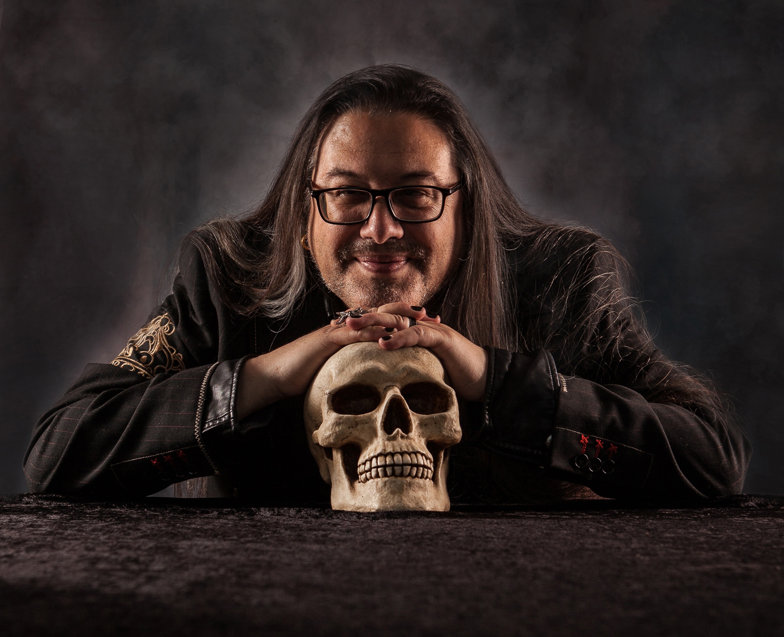 John Romero leaning on a skull
