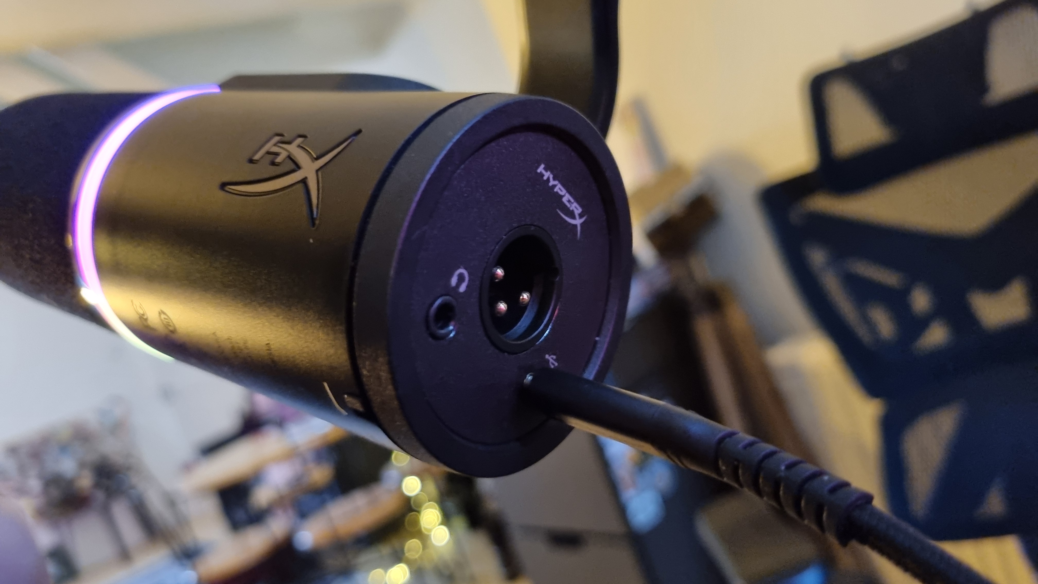 A HyperX FlipCast microphone shot from various angles to show the connection options and controls