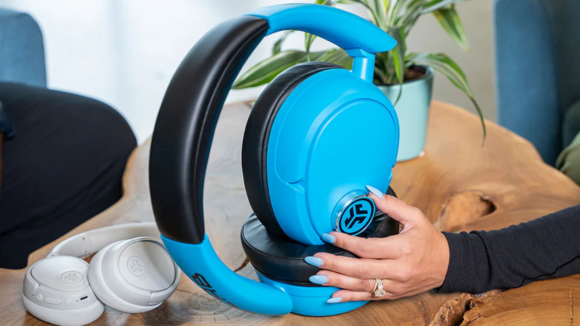 Models demonstrating JLab Audio's oversized Blue XL headphones