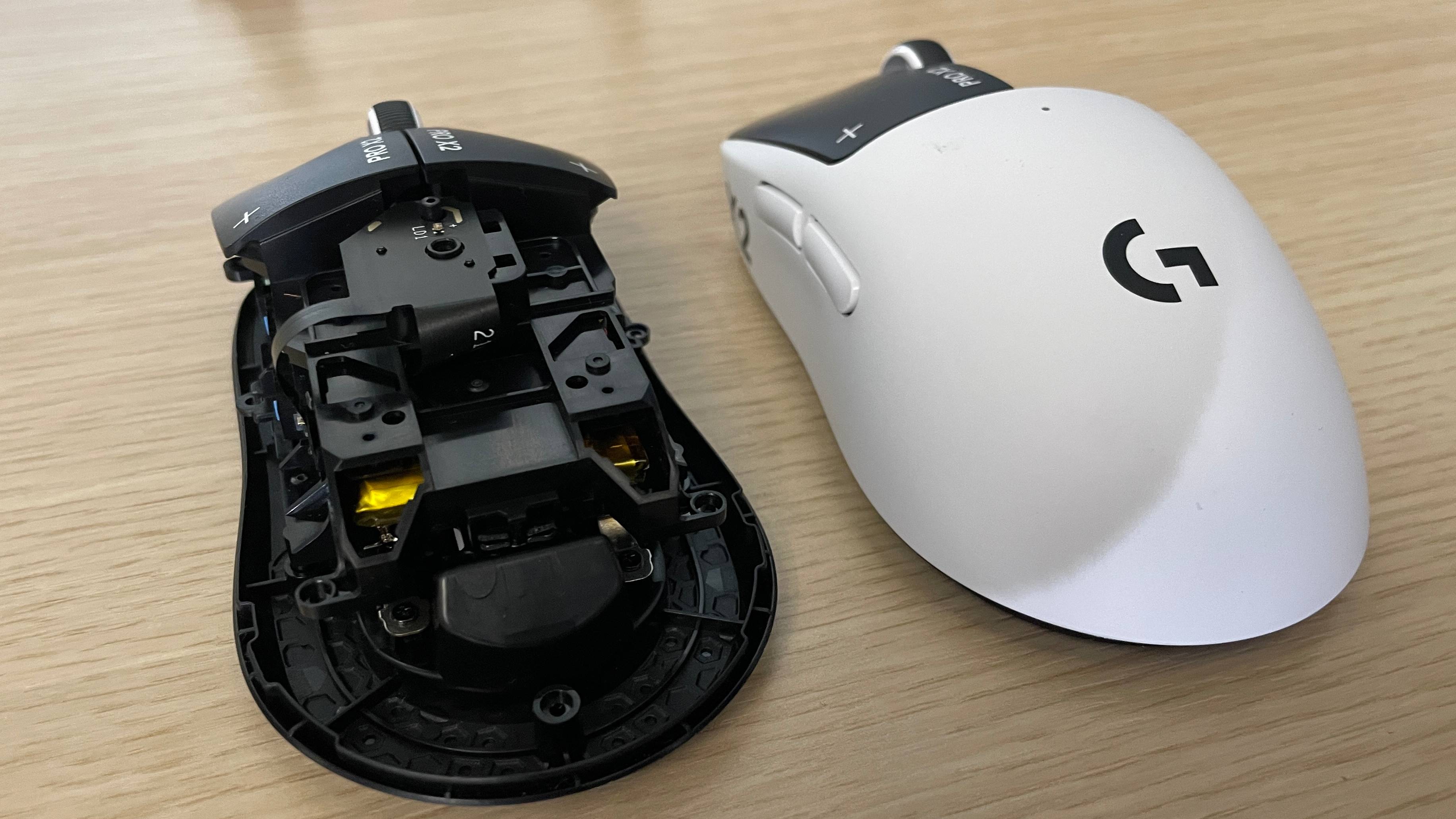 A Logitech G Pro X2 Superstrike gaming mouse next to a version of it with its shell off, showing its internals.