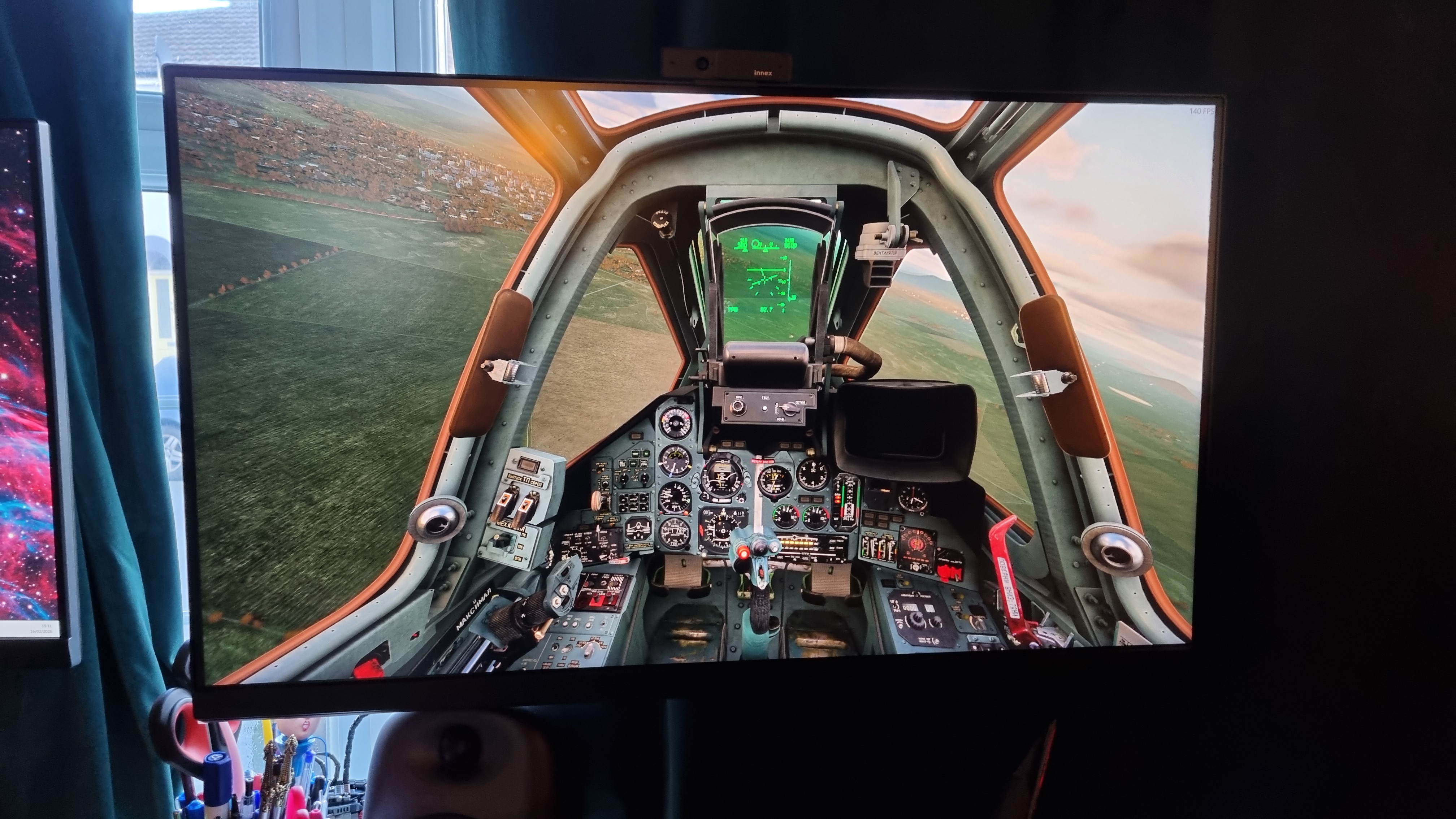 A photo of a 32-inch monitor displaying DCS World, with a jet fighter cockpit soaring above... Georgia I forget
