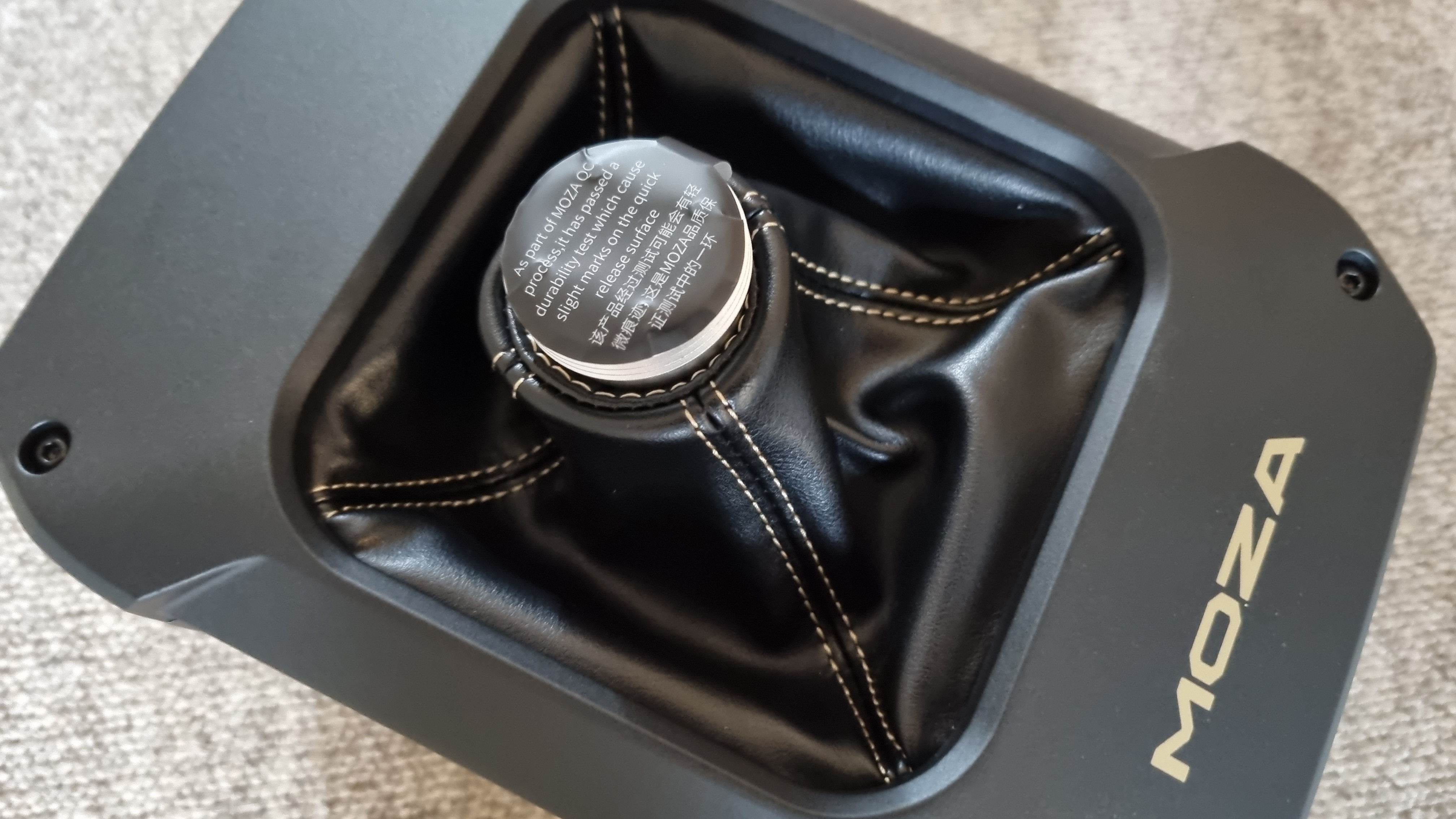 A top-down view of the Moza AB9 FFB Base with its shipping sticker still attached