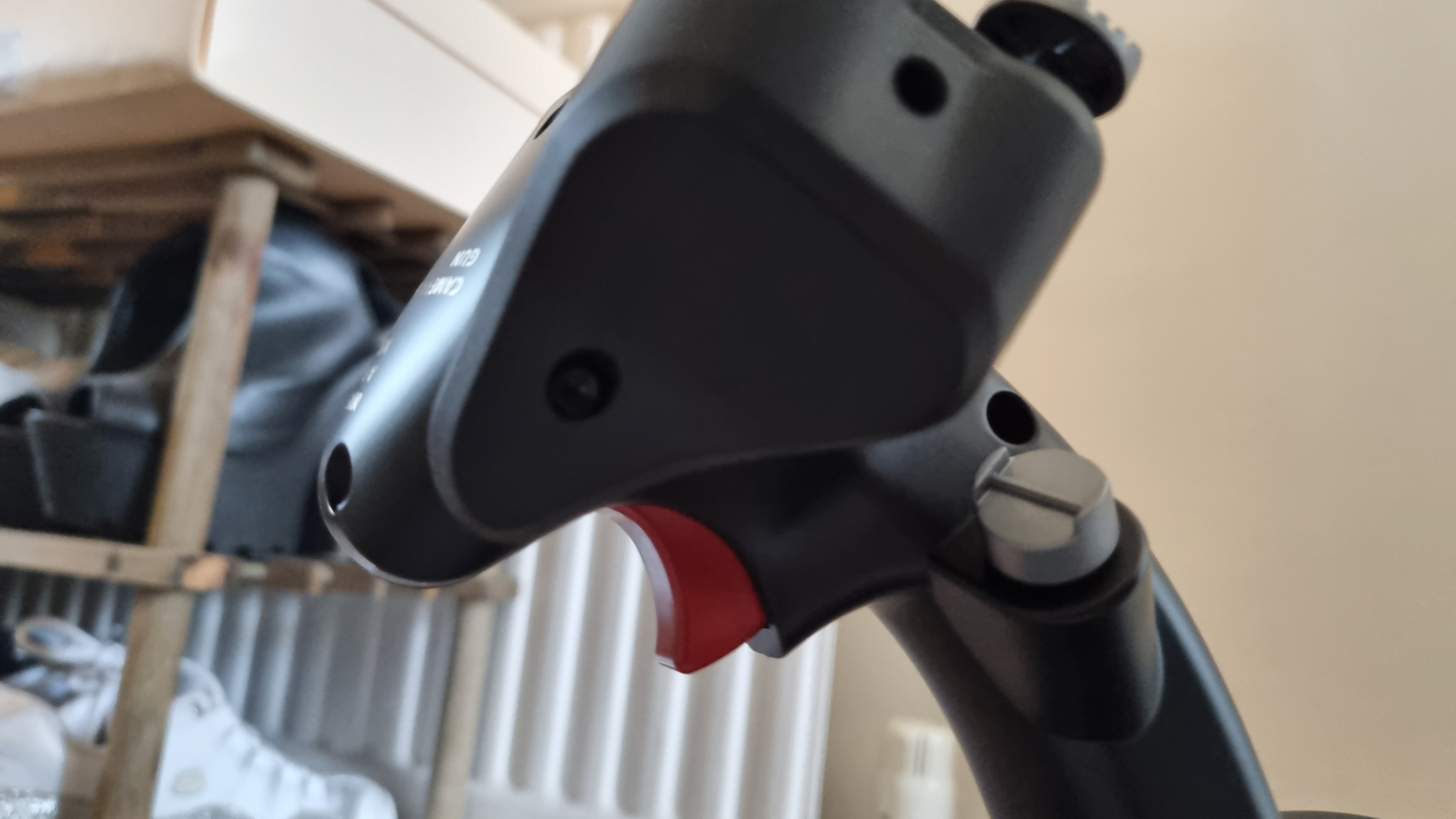 The underside of the Moza MH16 Flightstick, showing the red trigger and the side of the removable control module