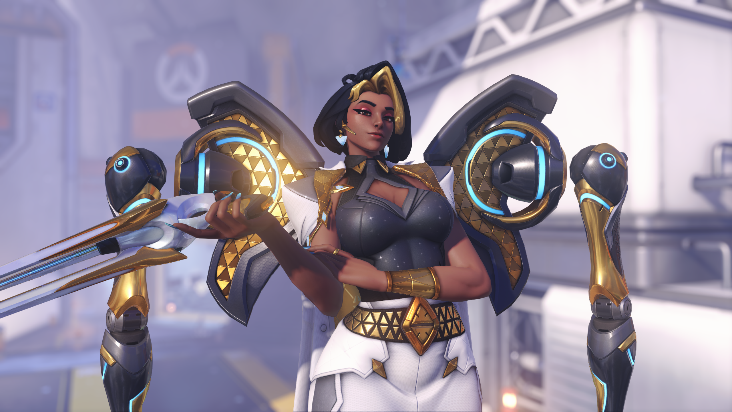 An in-game screenshot of an Overwatch hero. A short-haired woman with two mechanical arms at her shoulders with gold accents grins at the viewer.