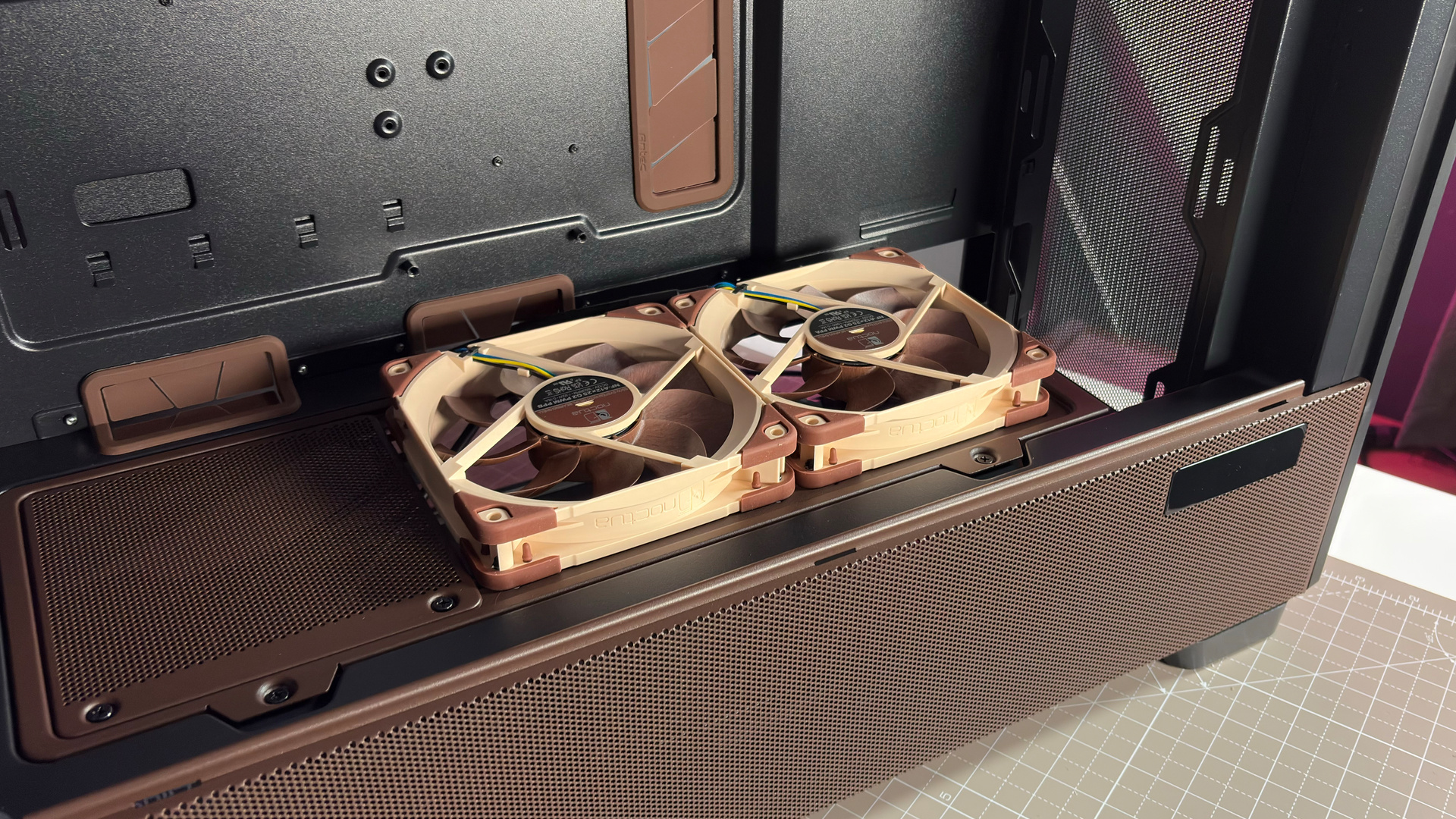 The Antec Flux Pro Noctua Edition on a desk with various parts disassembled.