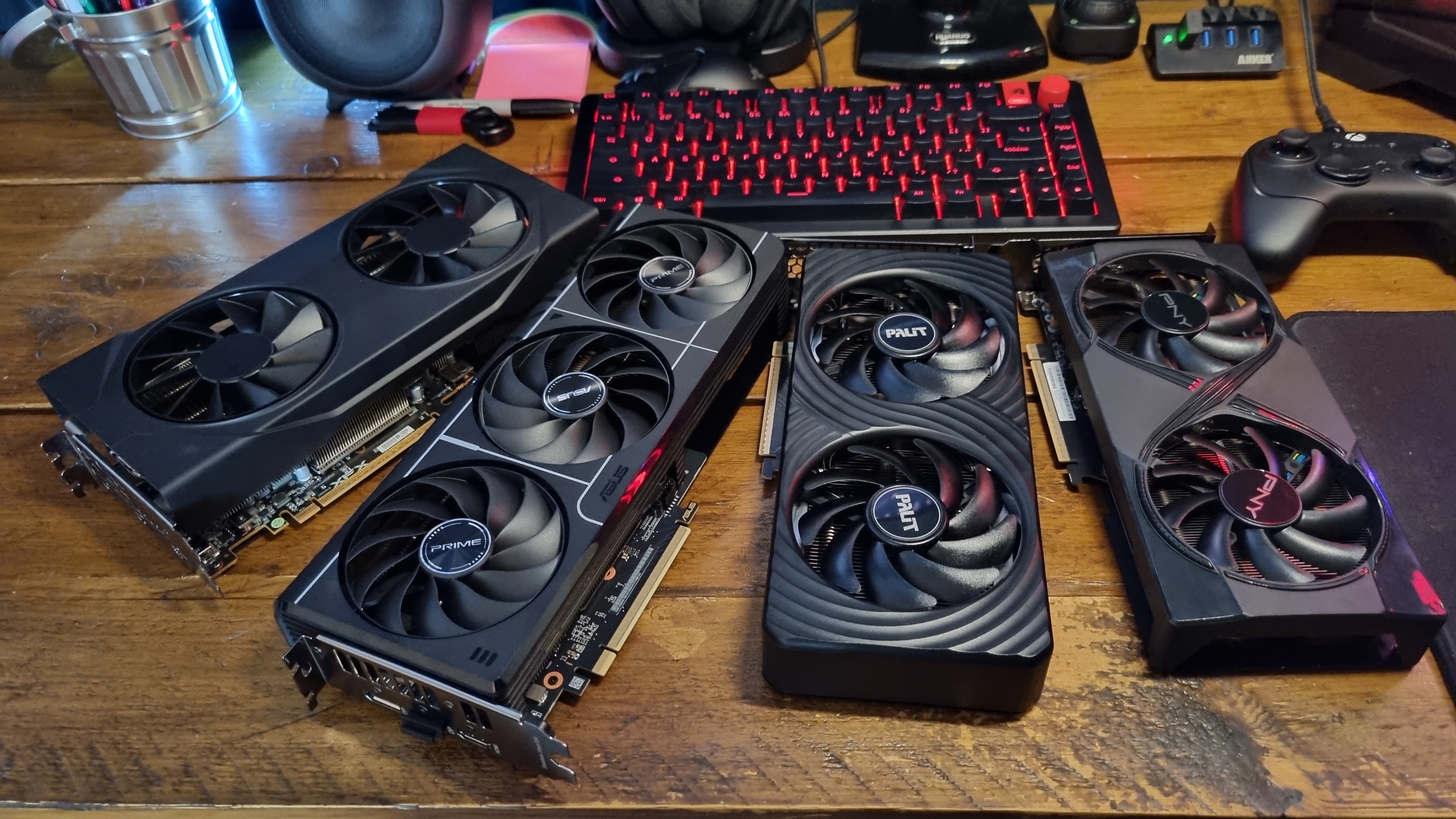 Four budget graphics cards on a wooden desk, splayed out in a spiral configuration