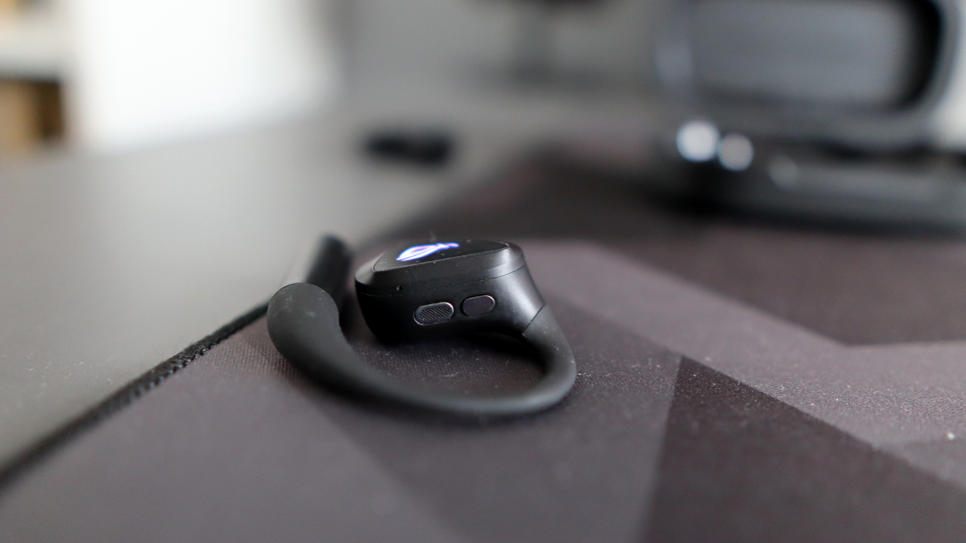 Asus ROG Cetra Open earbuds on a deskmat.