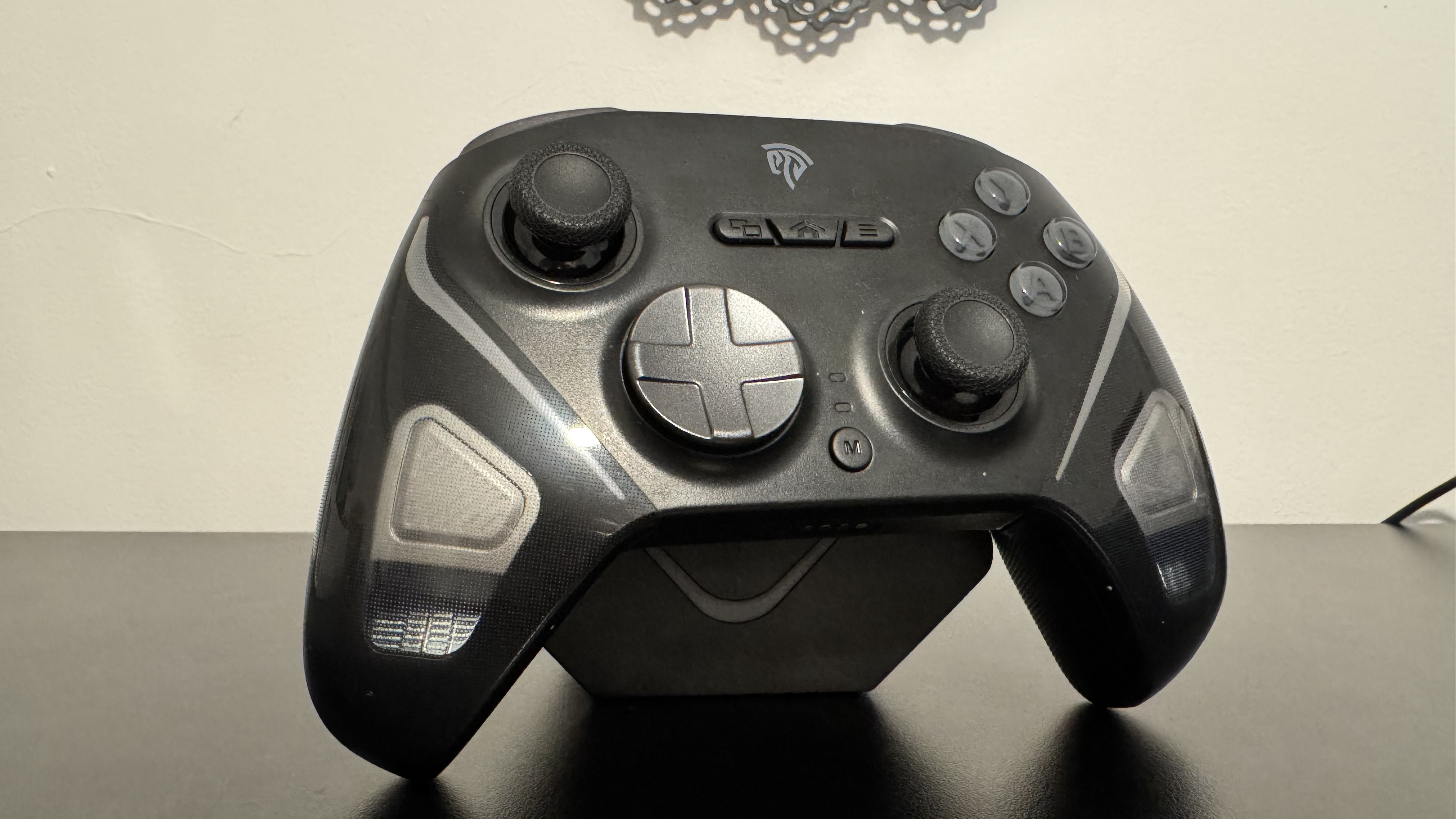 EasySMX D10 from the front, on the charging stand (while off) on a black desk