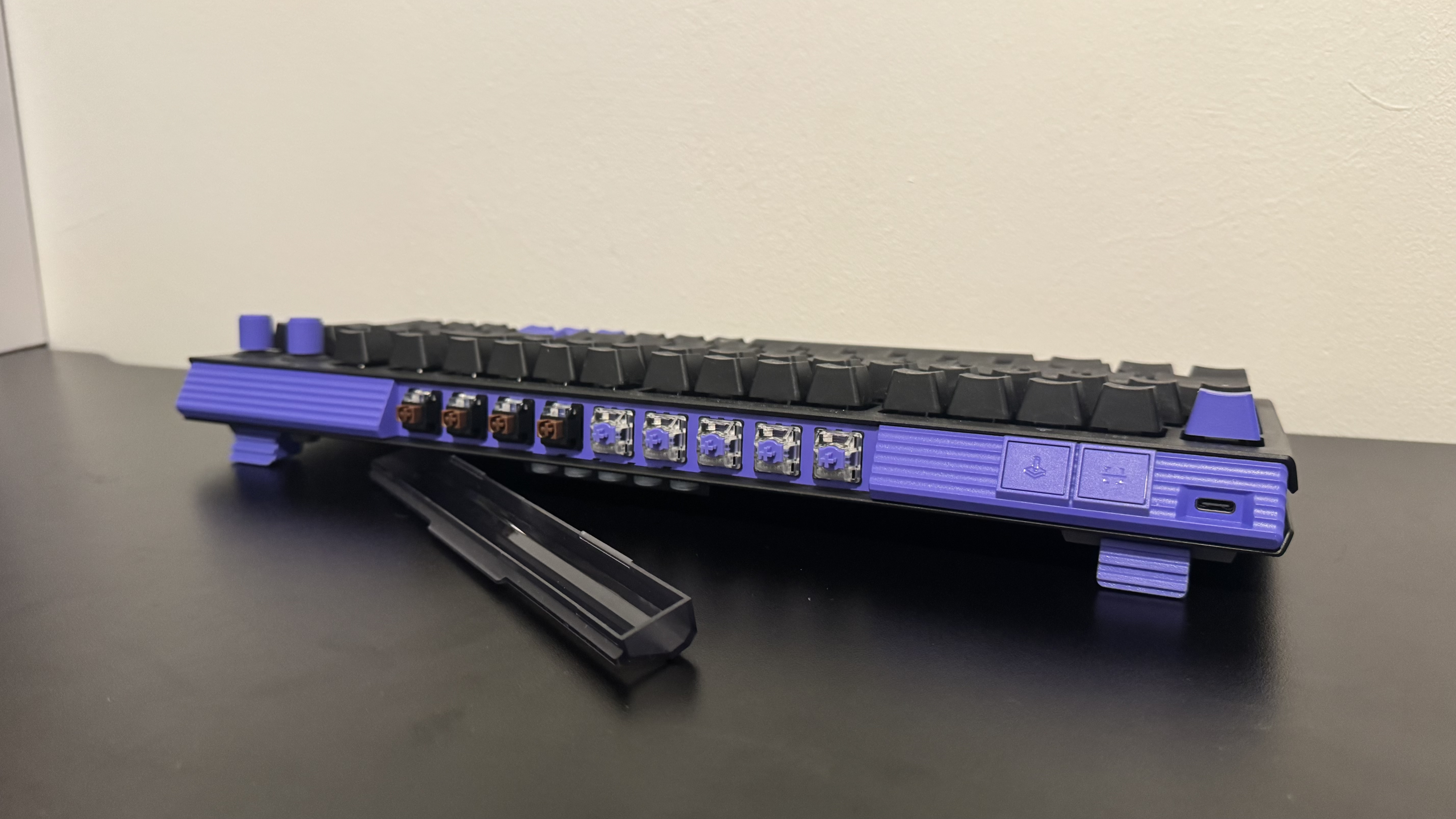 The Logitech G512 X gaming keyboard from the back, showing a compartment with extra switches