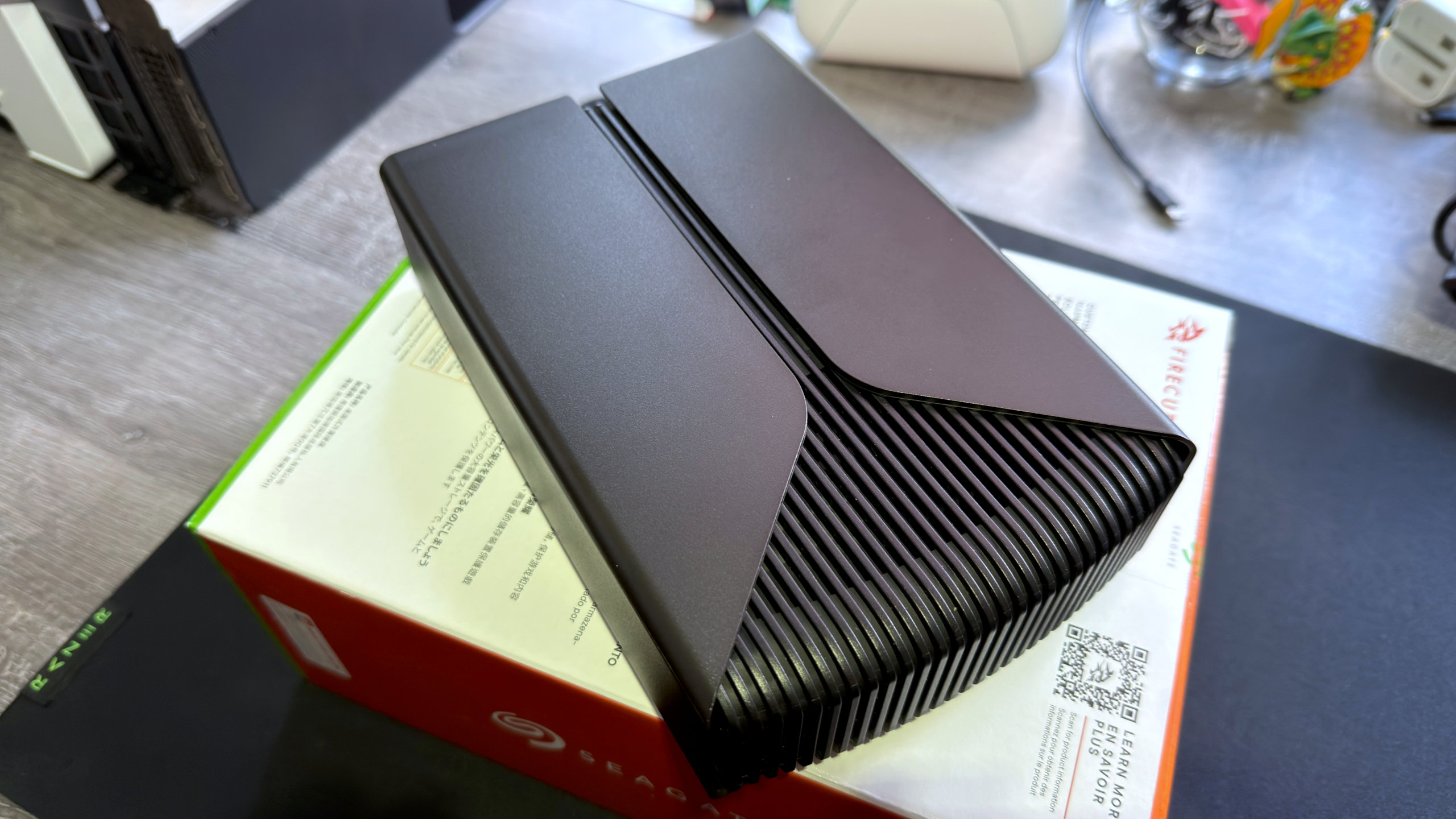 A photo of a Seagate FireCuda X Vault external hdd, resting on its retail packaging