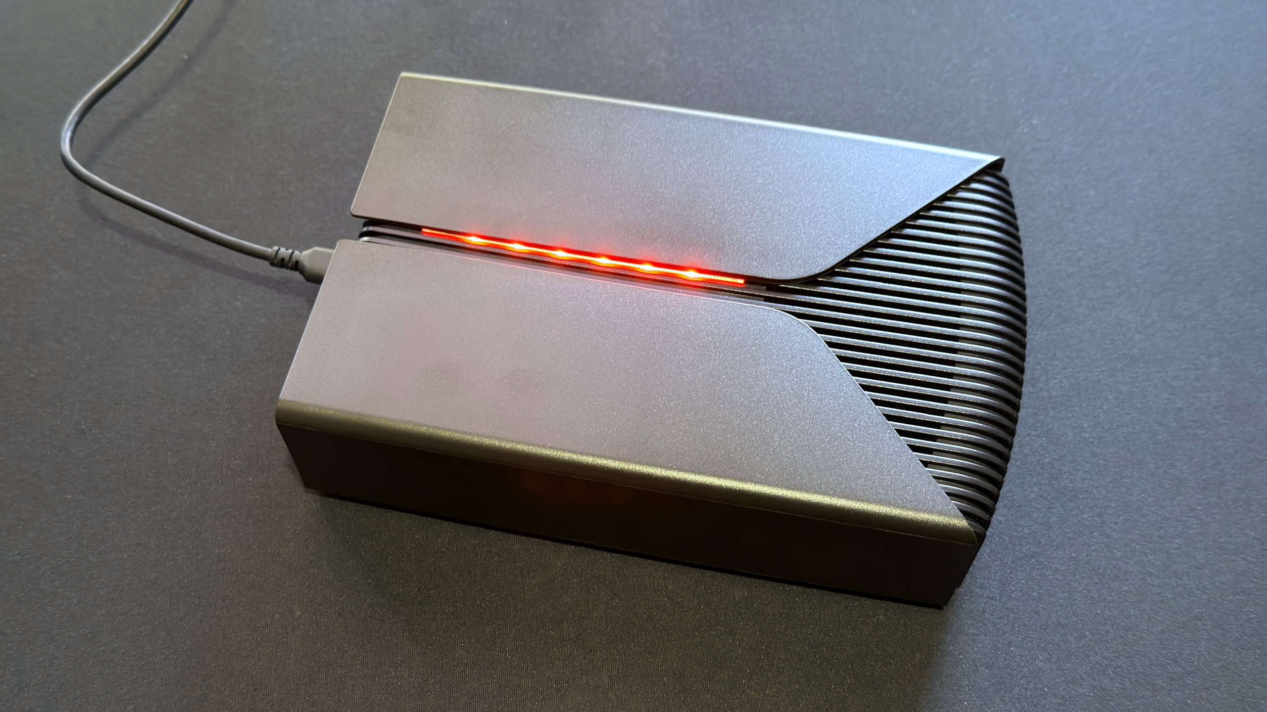 A photo of a Seagate FireCuda X Vault external hdd, powered via a USB Type-C cable, with its RGB lighting active