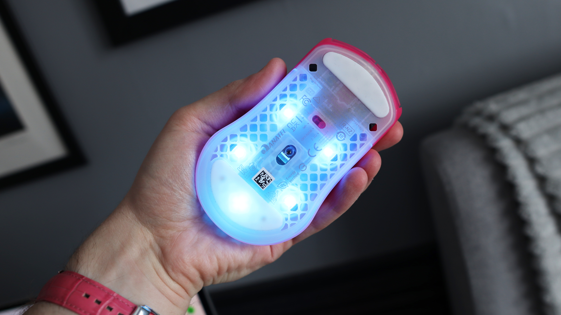 The SteelSeries Aerox 3 Wireless Gen 2 looking excellent in pink on a grey mousepad.