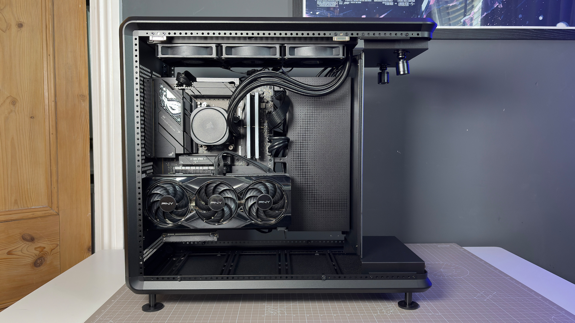 The CoolerMaster MasterFrame 360 Panoramic PC case with various components installed on a desk.