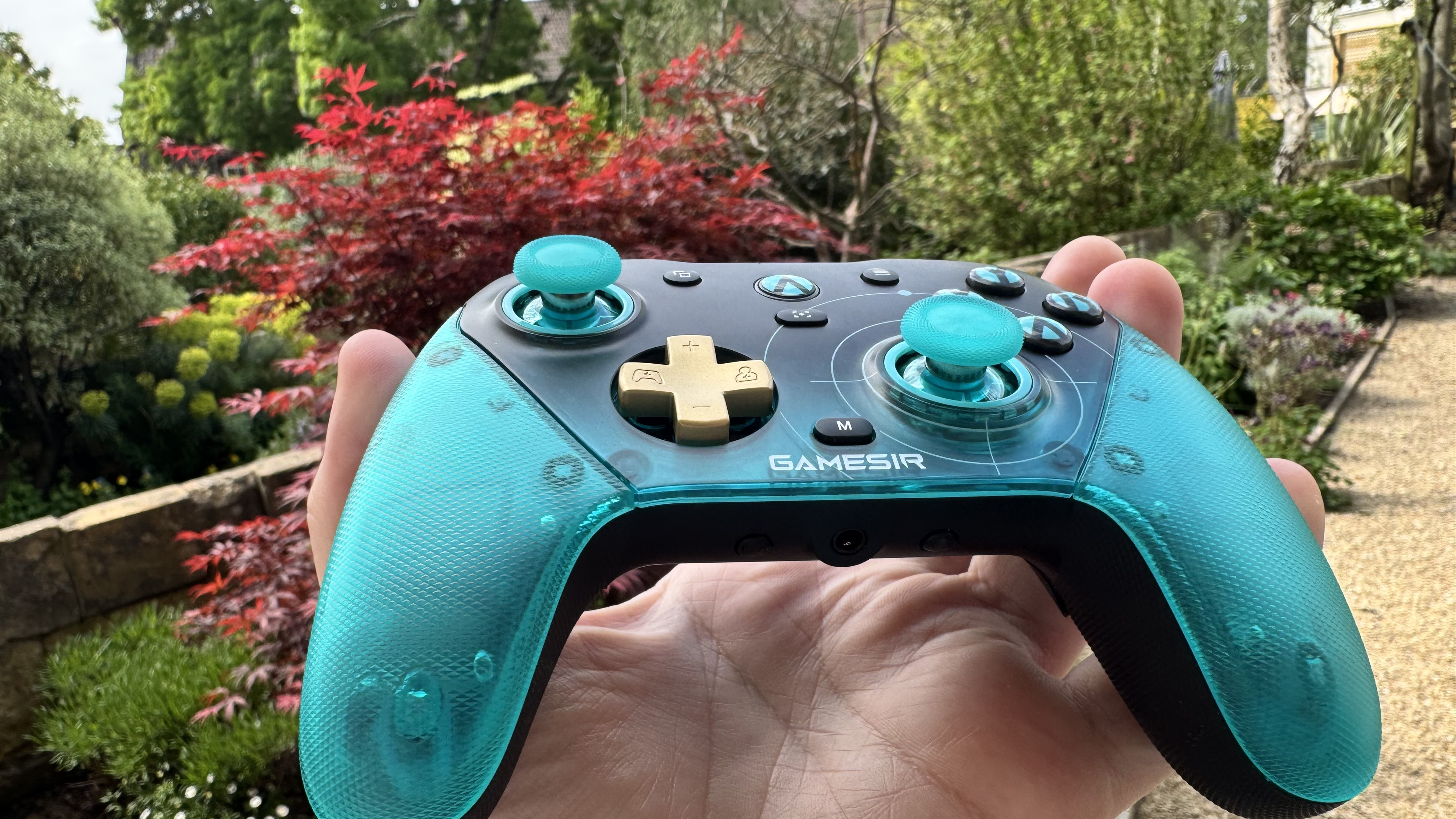 The GameSir G7 Pro 8K Aimlabs Edition from below, in a hand, outside