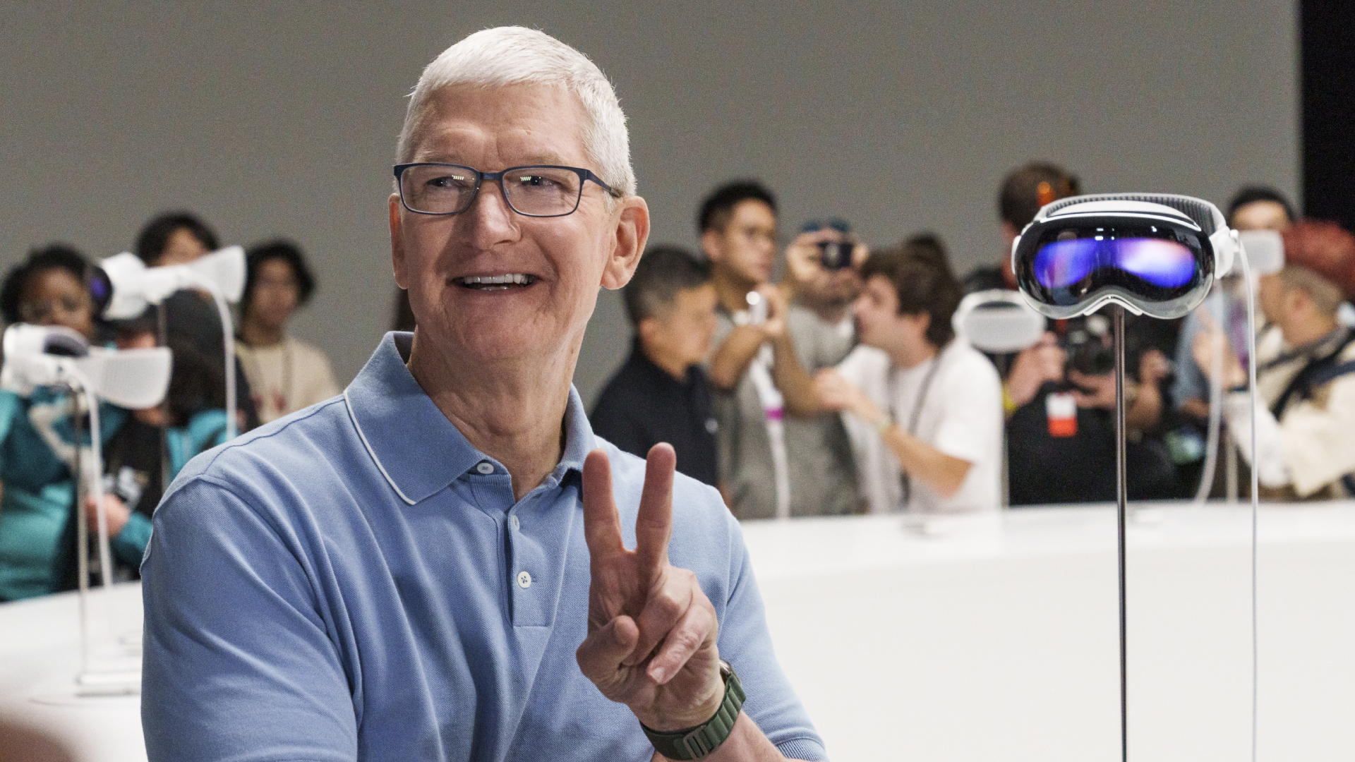 Tim Cook, chief executive officer of Apple Inc., beside an Apple Vision Pro mixed reality (XR) headset during the Apple Worldwide Developers Conference at Apple Park campus