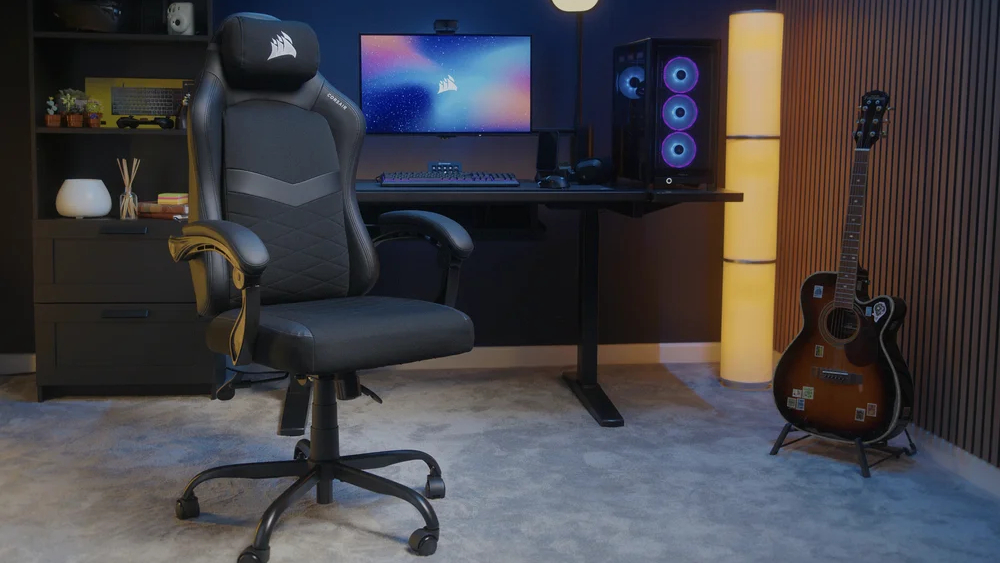 A Corsair TC80 gaming chair in a room next to a gaming PC, desk, and guitar.