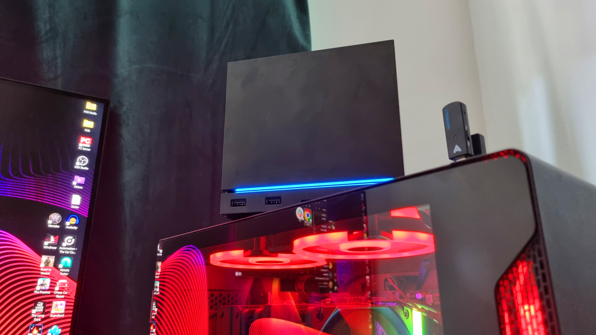 A Steam Machine sitting on top of a gaming PC, next to a 4K monitor