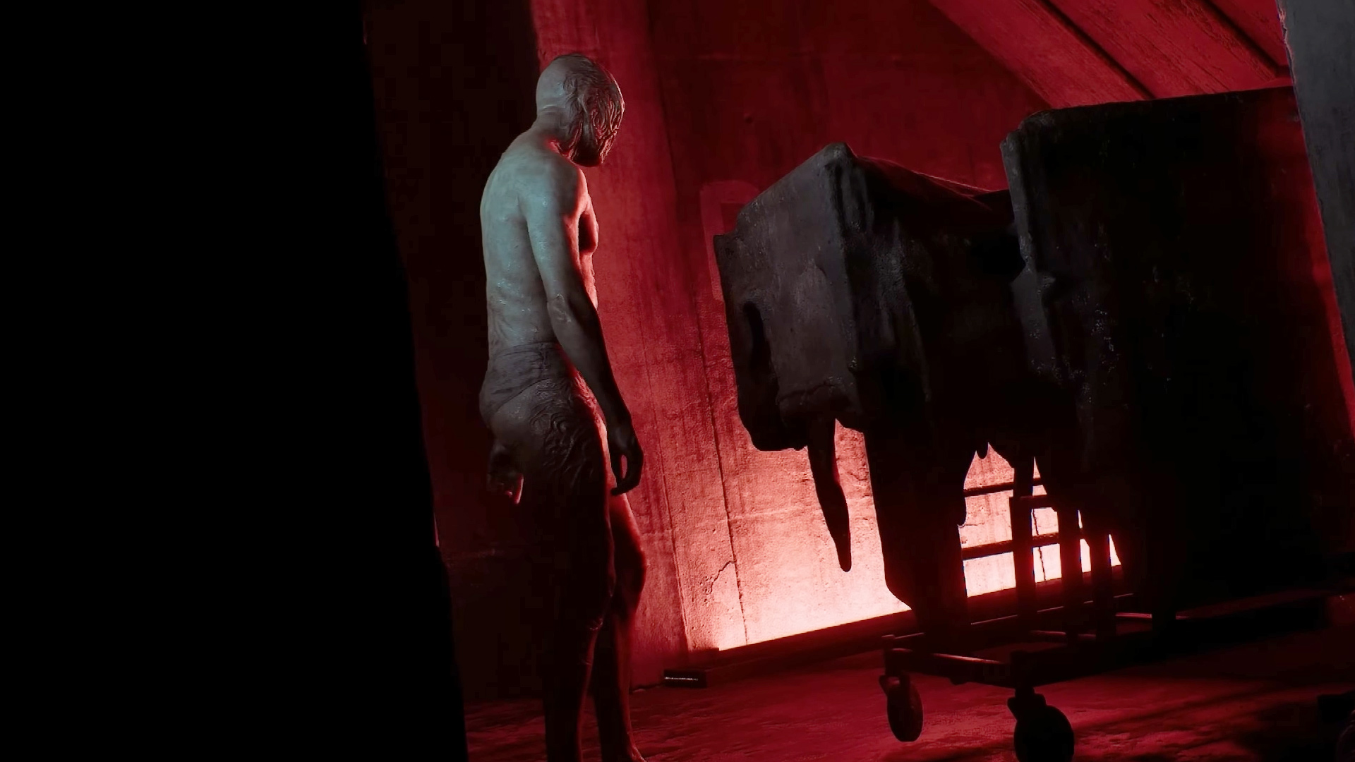 Silent Hill Townfall - A humanoid monster with its back to the camera in a dark room
