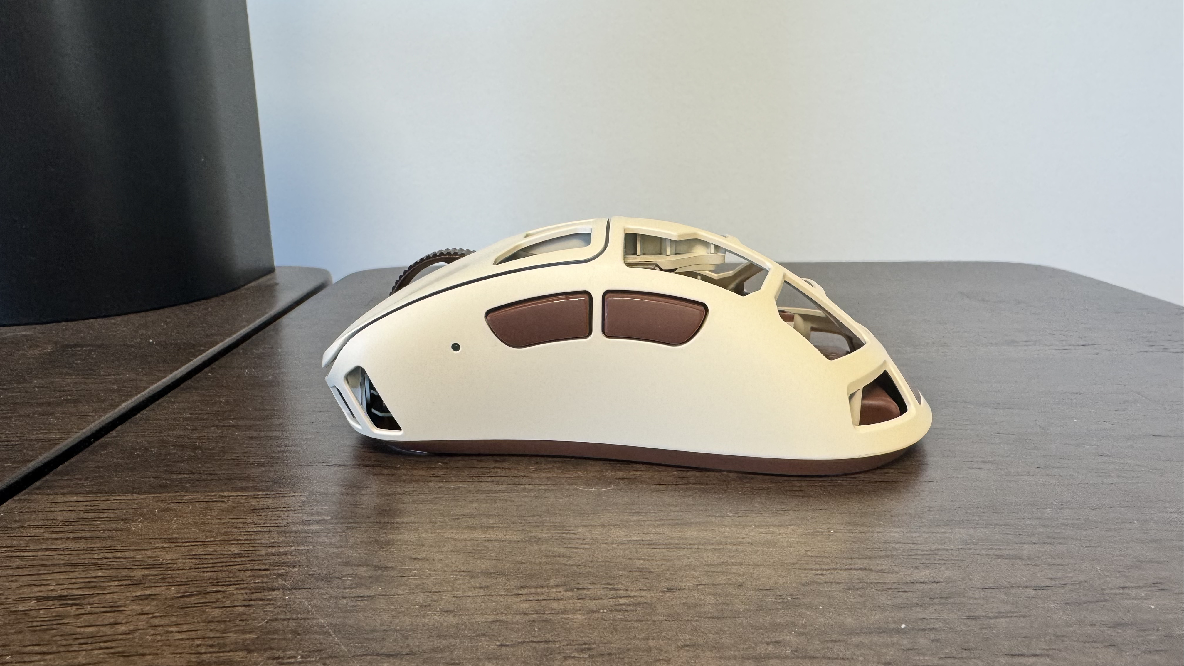 The Pulsar Feinmann F01 Noctua Edition gaming mouse on a wooden desk, from the left hand side