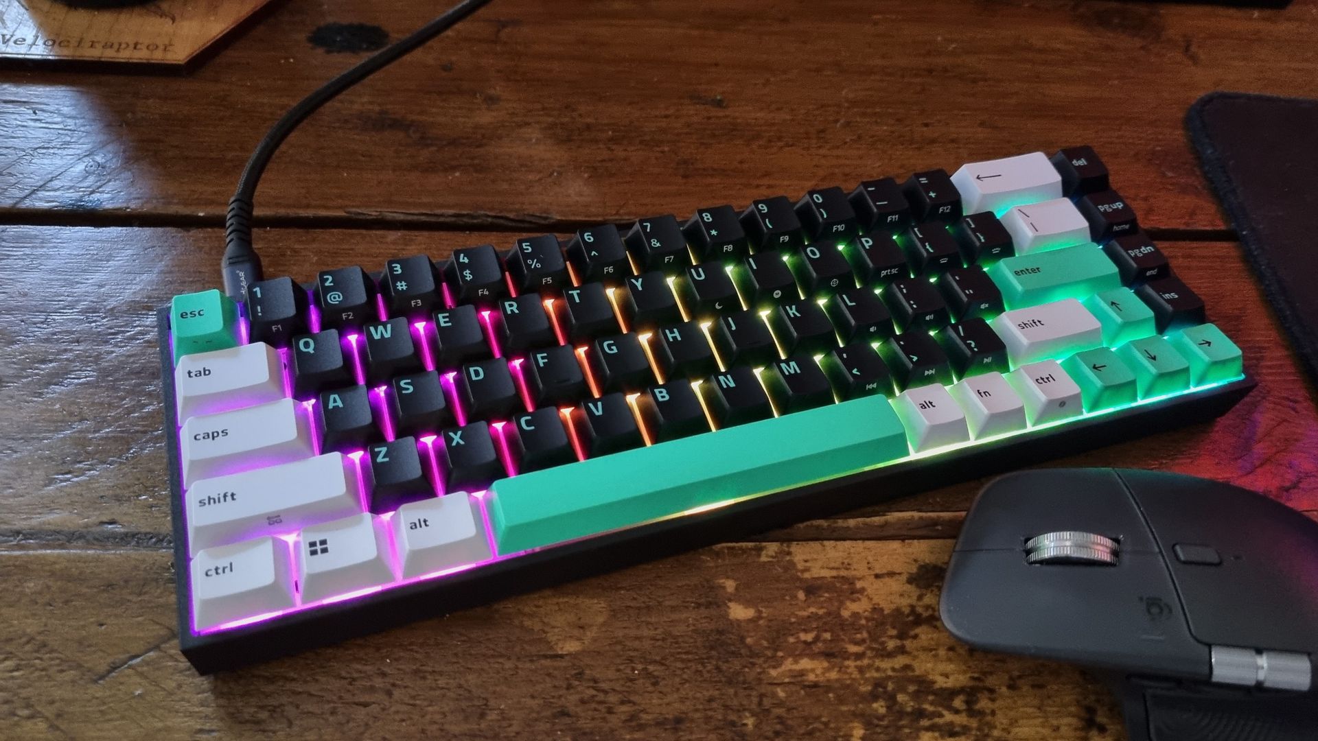The Razer Reclusa X Mini 65% gaming keyboard on a desk, with an ergo mouse underneath it