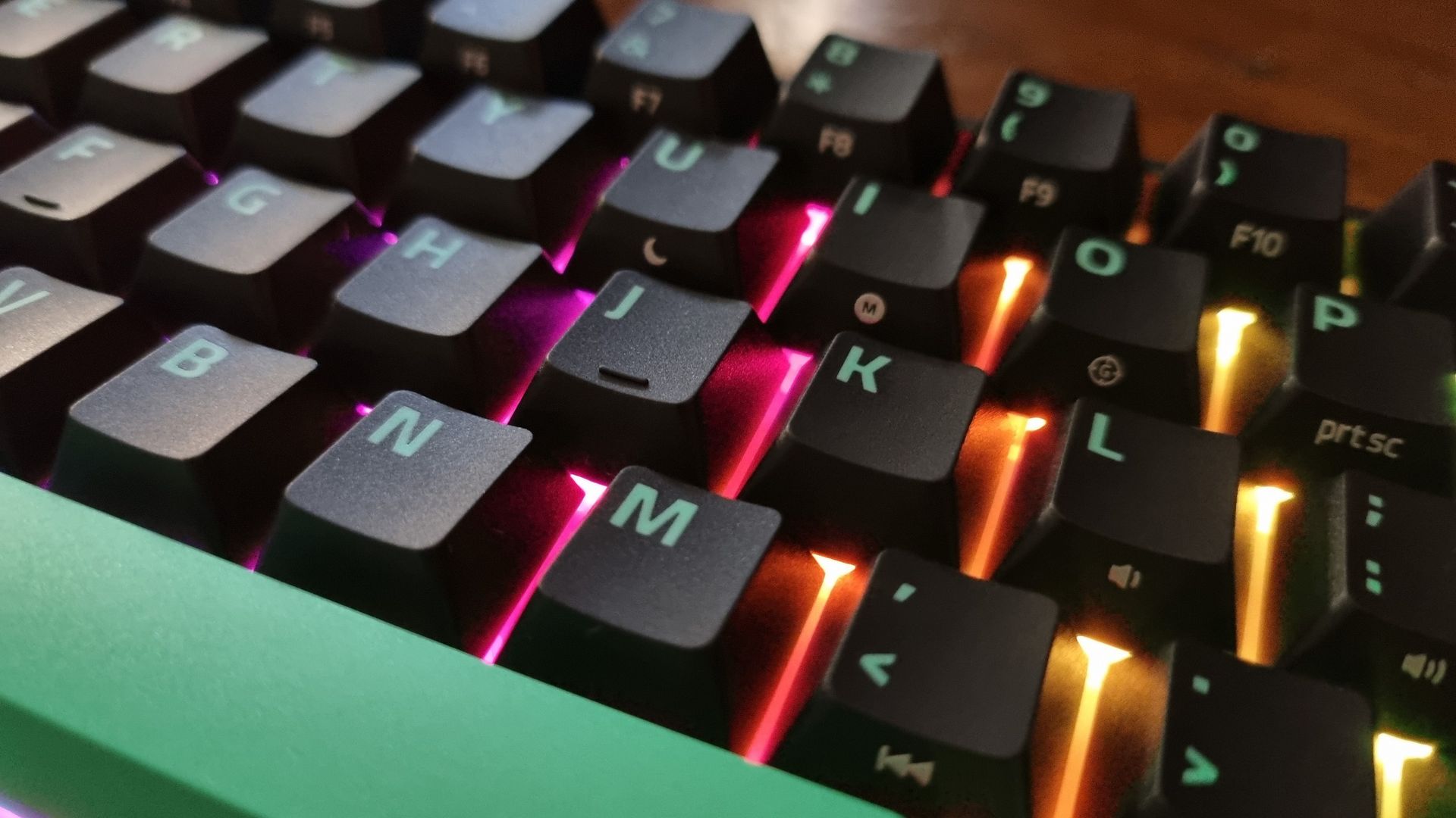 Close ups of the Razer Reclusa X Mini 65% gaming keyboard showing the RGB lighting effect
